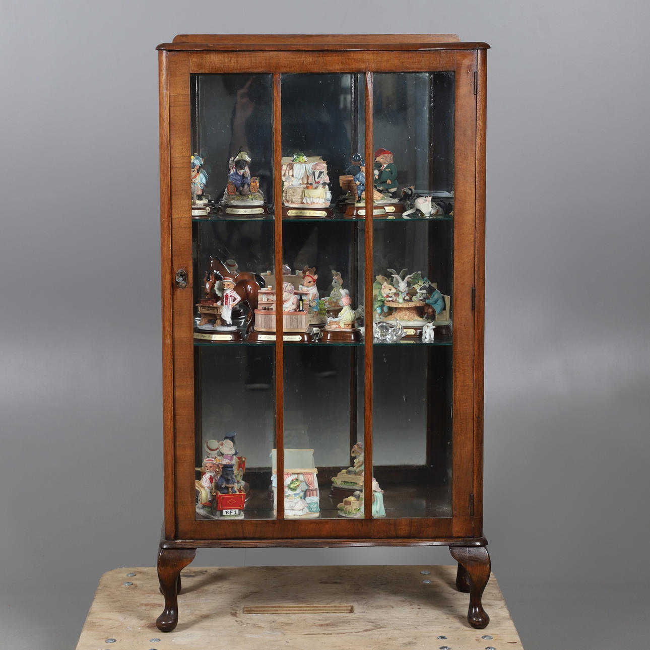 EINE SAMMLUNG VON HARZFIGUREN UND EINE KLEINE VITRINE.