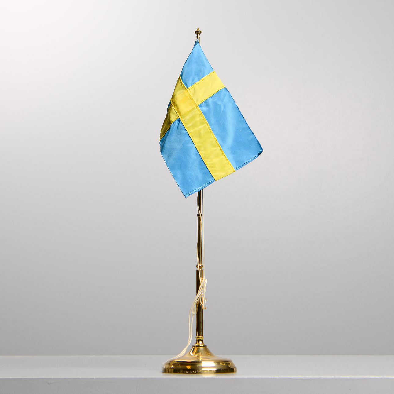 SKULTUNA, bordsflagga, mässing.