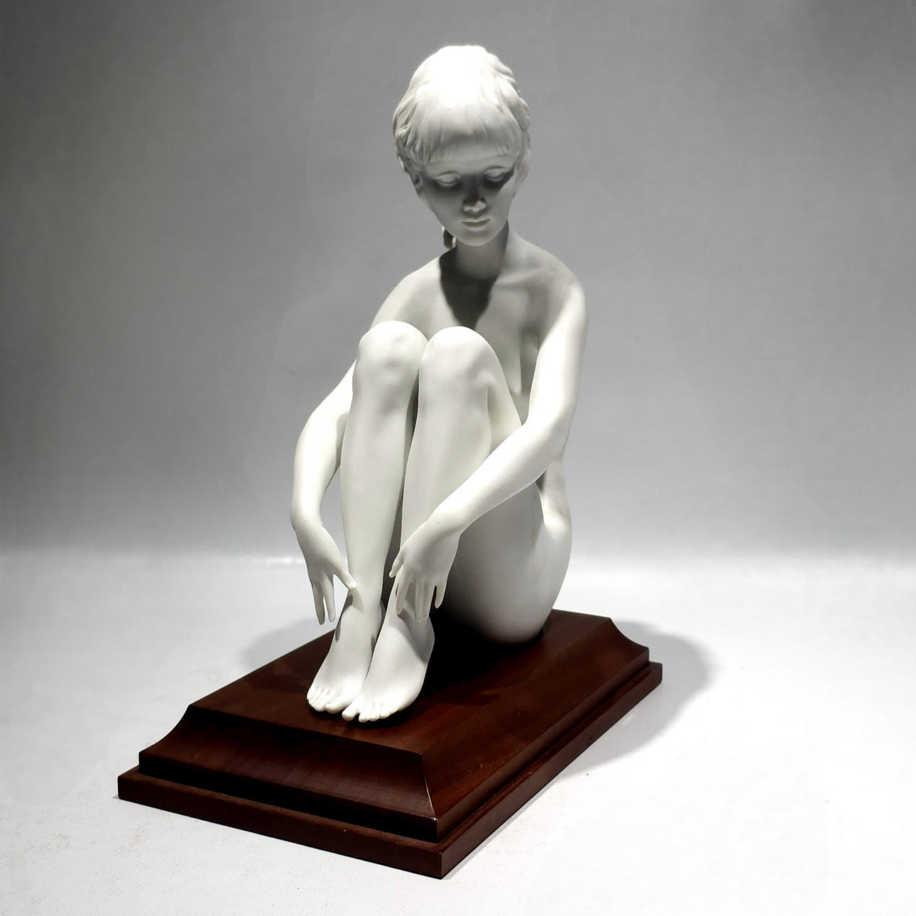 KAISER. Ung kvinde sidder på porcelæn.