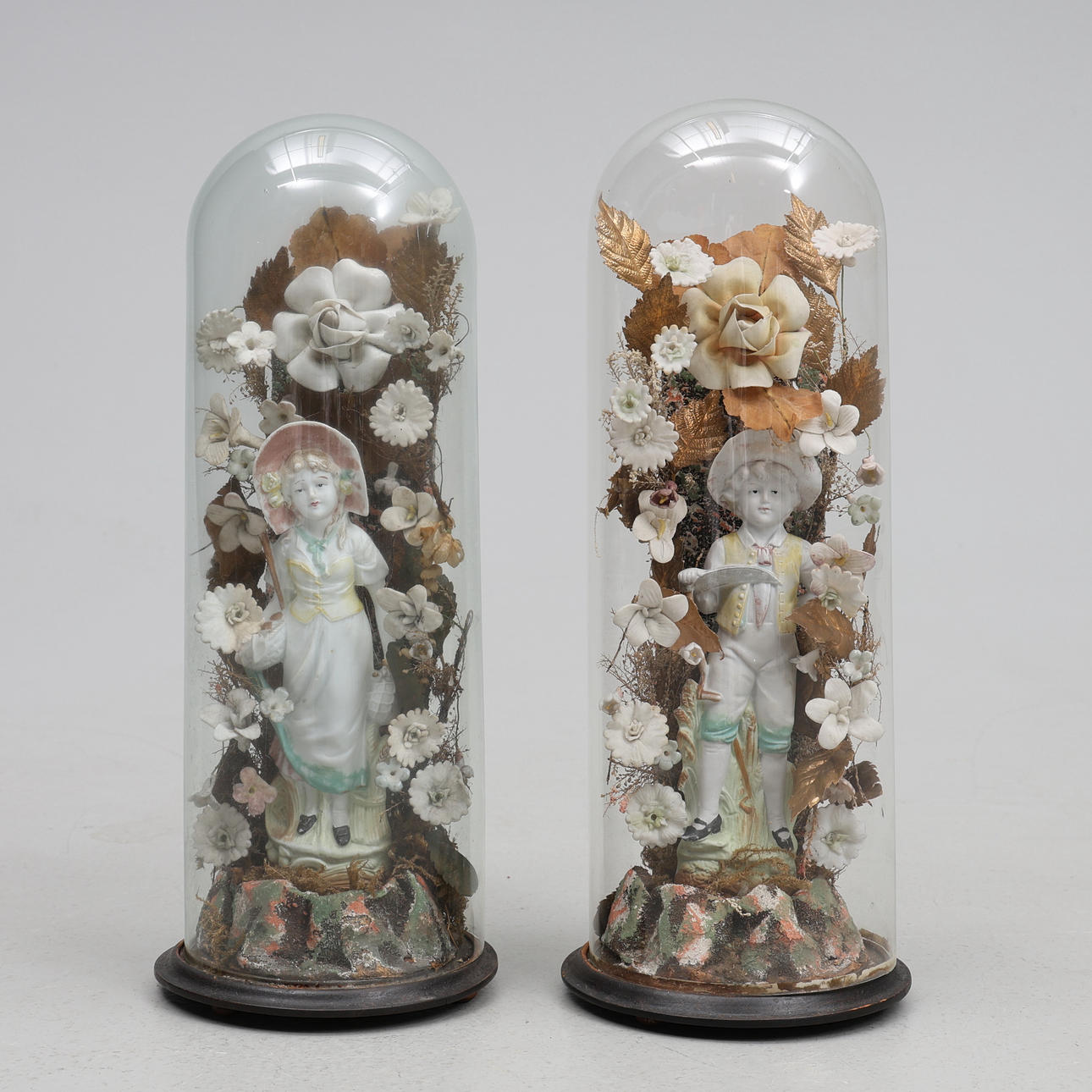 2 GLASS DOMES WITH PORCELAIN FIGURINES.