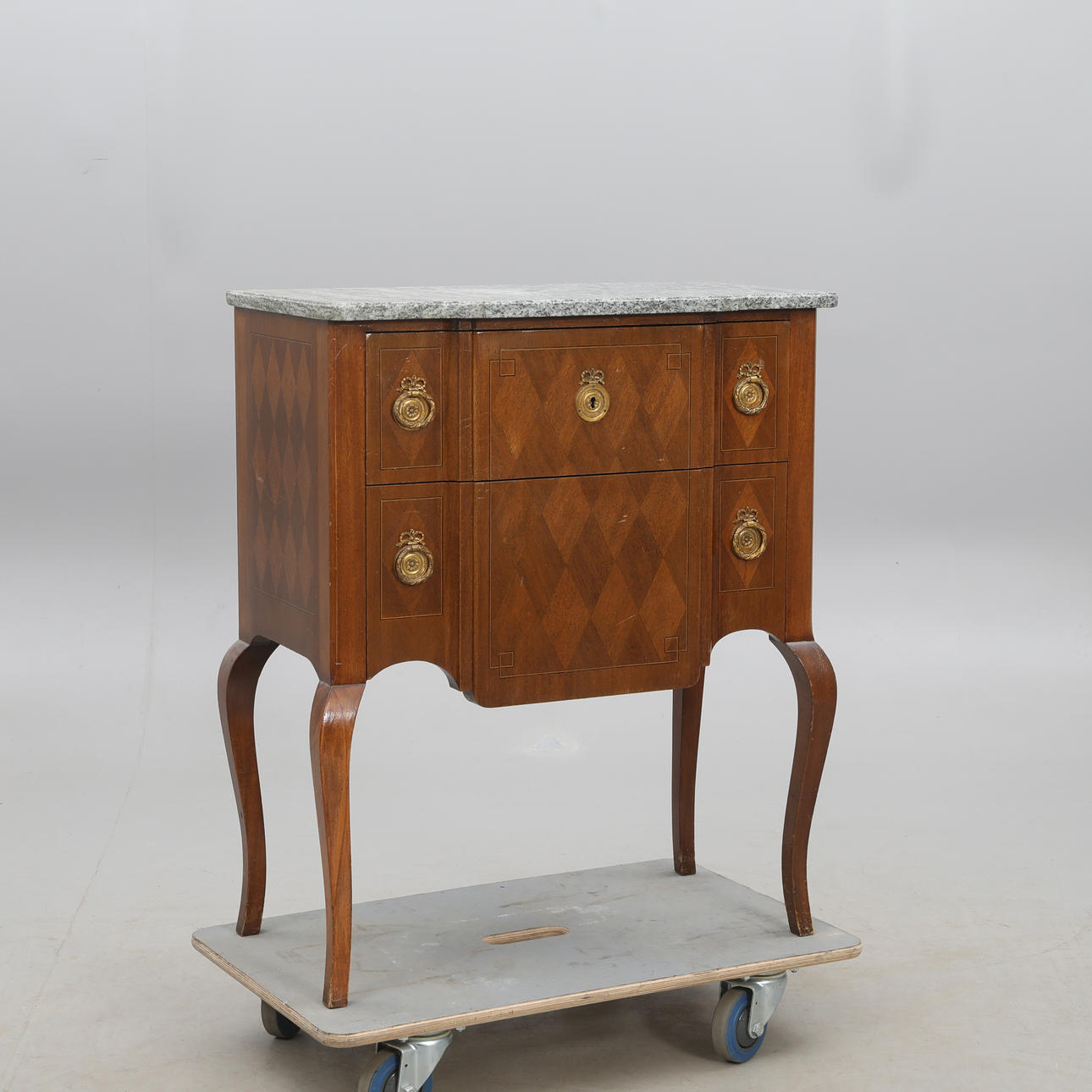 Còmoda de cajones, con tapa de piedra, de estilo rococó.