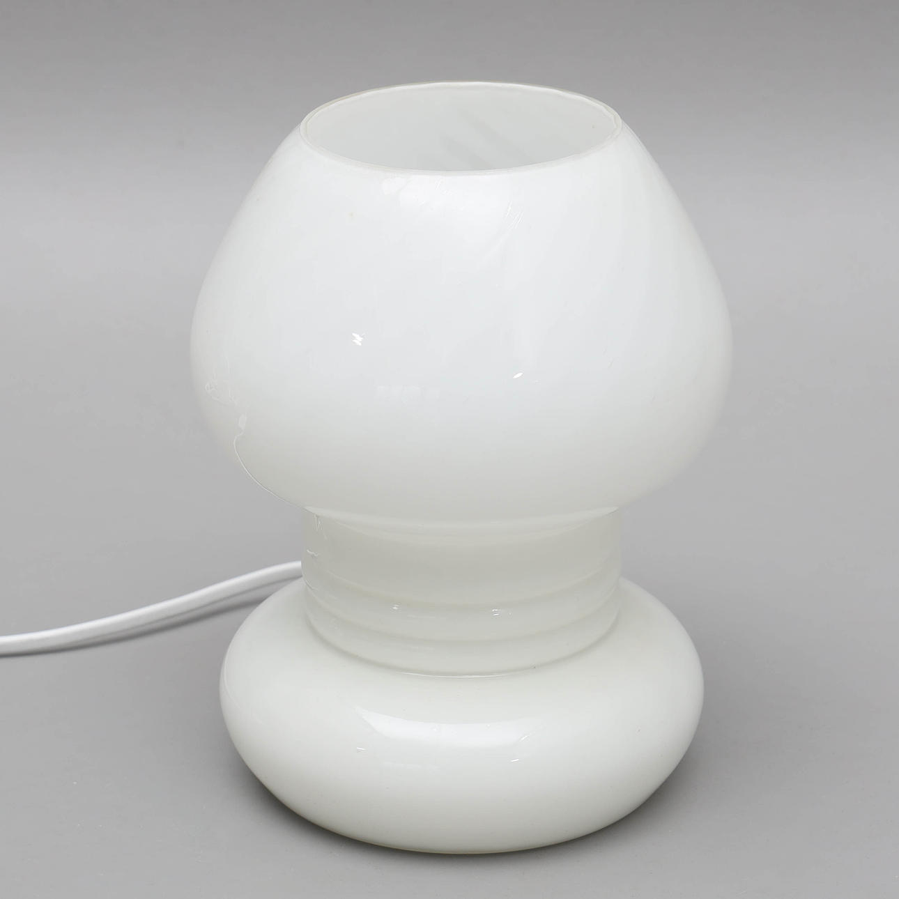 A glass “swirl” table lamp, second staple of the 20th century.