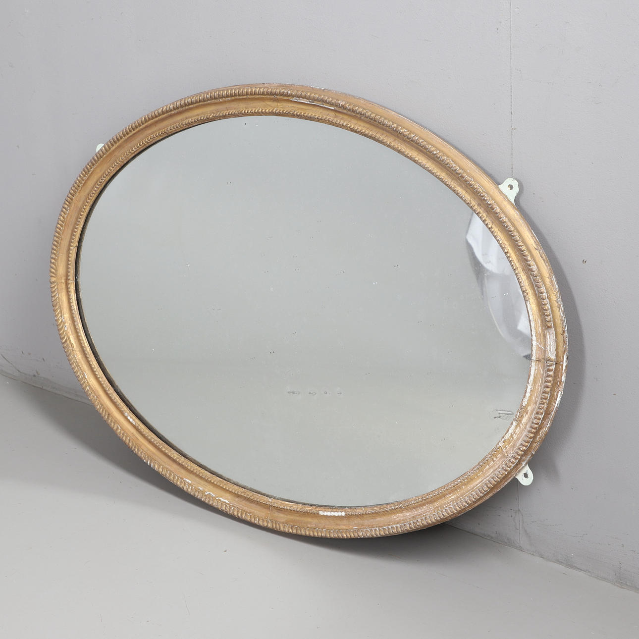 A MOULDED PLASTER GILT FRAME WALL MIRROR.