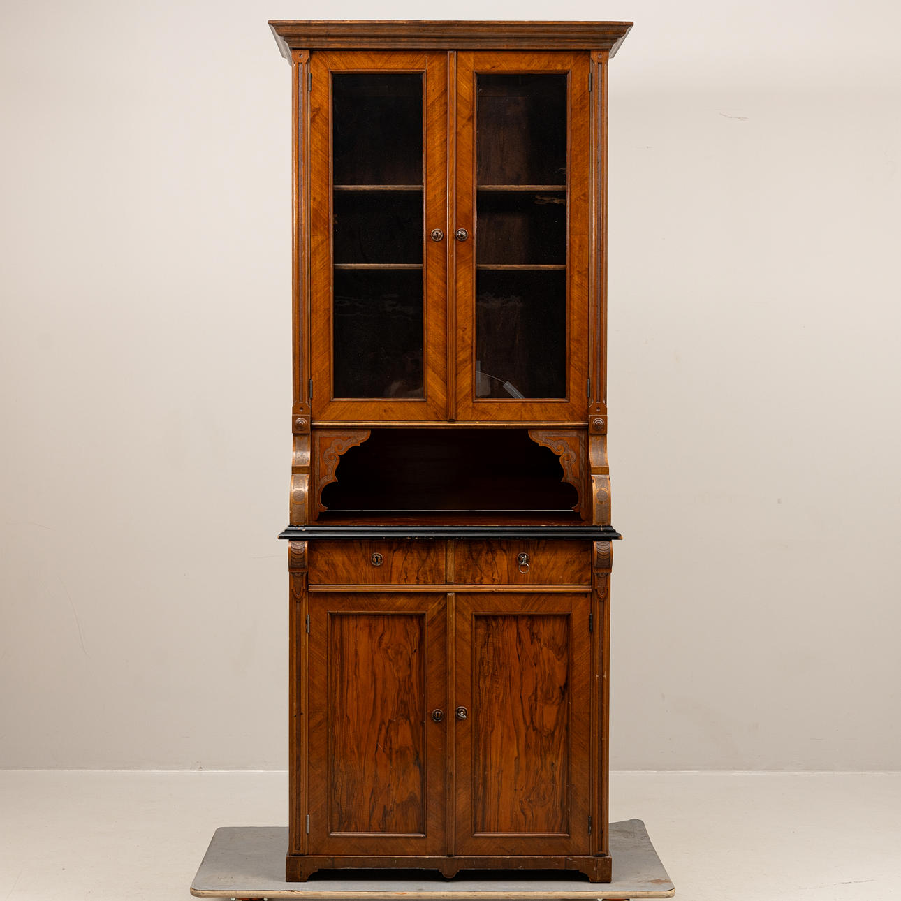 A two-piece, walnut veneer bookcase, circa 1900.