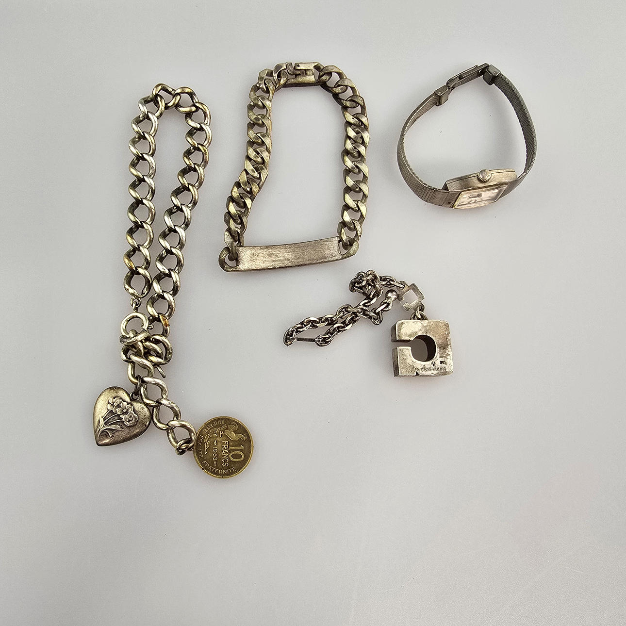 - En samling af gamle sølvsmykker, armbånd, urkæde.