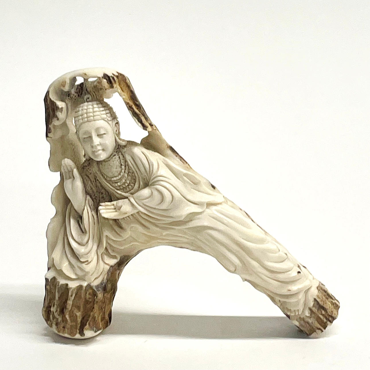 BUDDHISTISCHE FIGUR AUS GESCHNITZTEM HIRSCHGEWEIH.