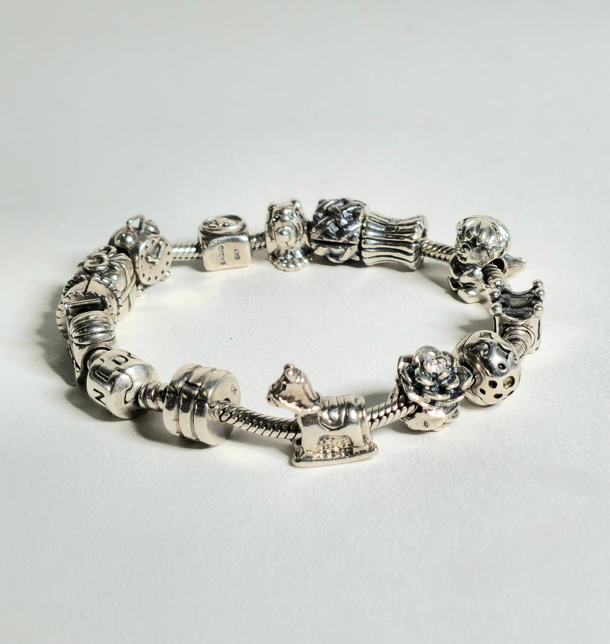 PULSERA ESTILO PANDORA EN PLATA CON 14 CHARMS.