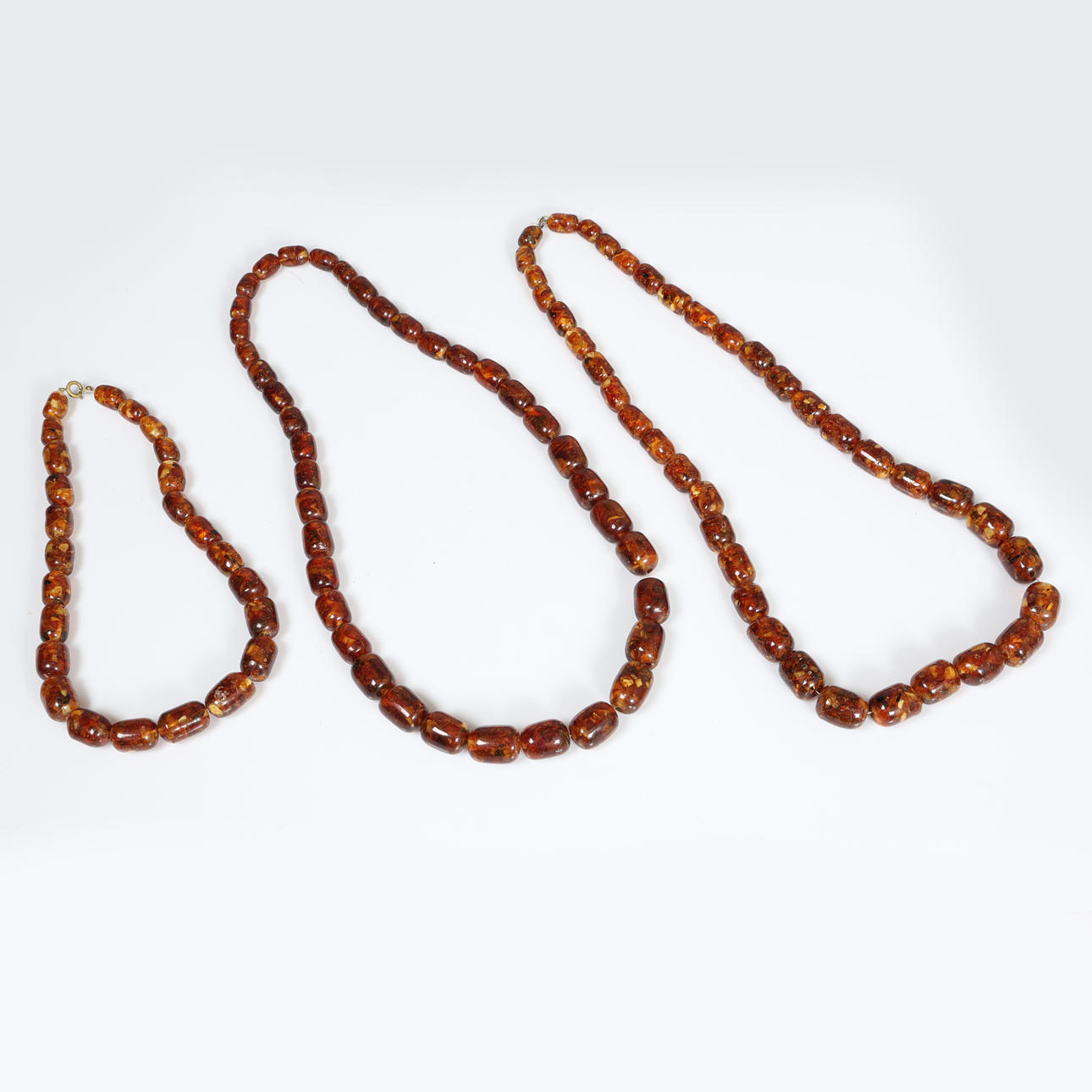 TRE BÄRNSTENSFÄRGADE PÄRLHALSBAND (3).