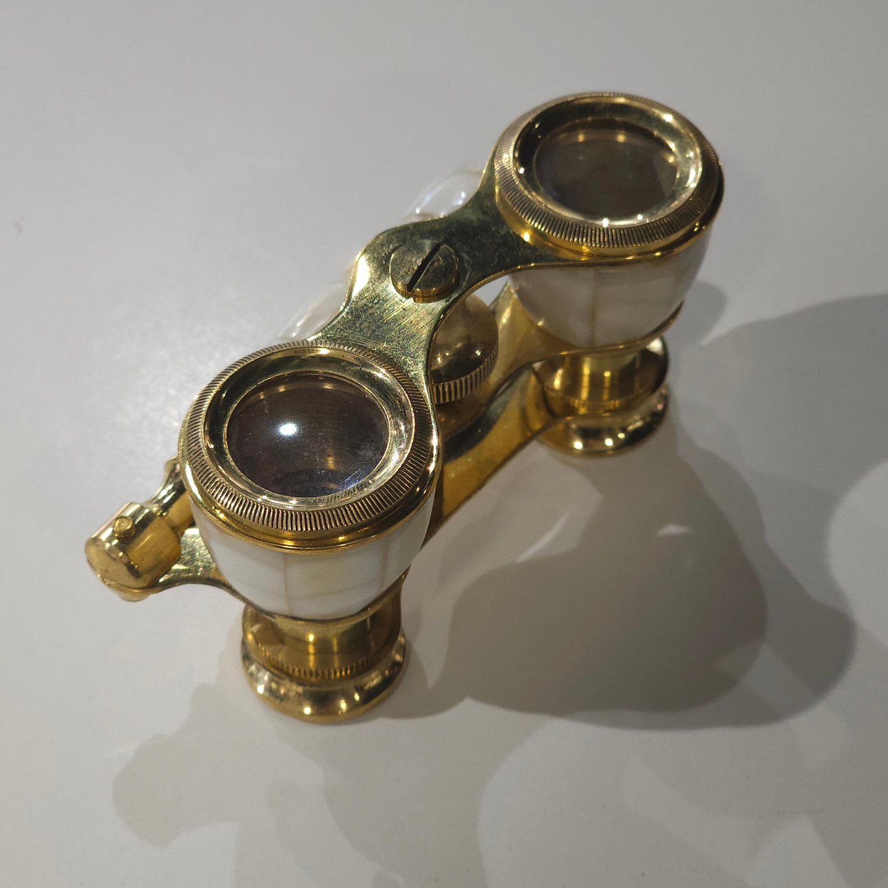Kikkert til teater i metal og perlemor.