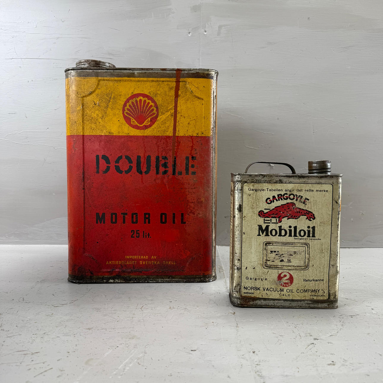 A shell and a gargoyle, two 20th century tin cans.