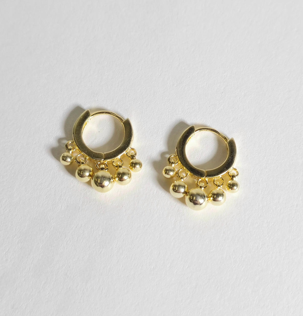 SØLVBELAGTE BØJLEØRERINGE MED GRADIENTPERLER.