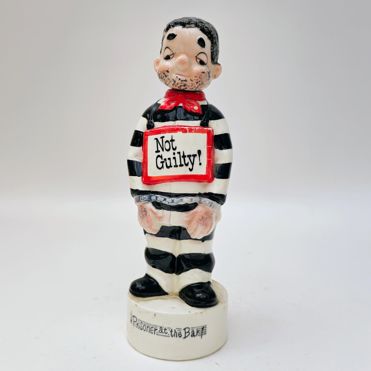 PRISONER. NOT GUILTY. MUSICAL BOTTLE. POLYCHROME CERAMIC. C. 1960S.