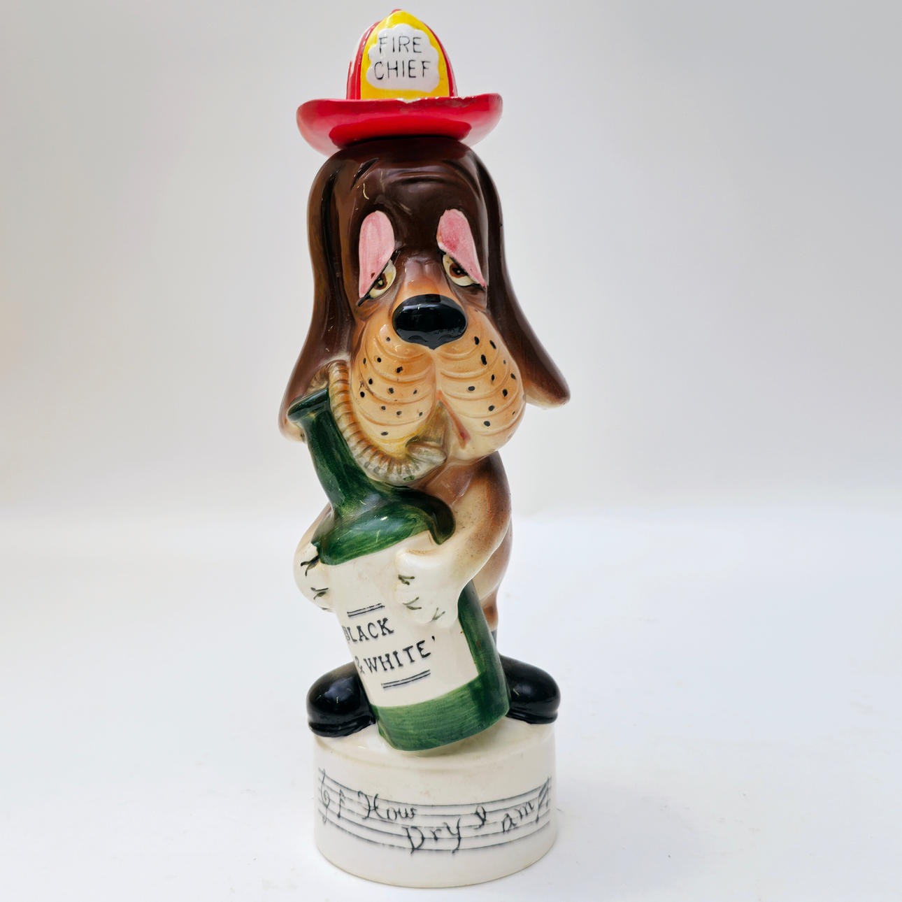 FIRE CHEF DOG. MUSICAL BOTTLE. POLYCHROME CERAMIC. C. 1960S.