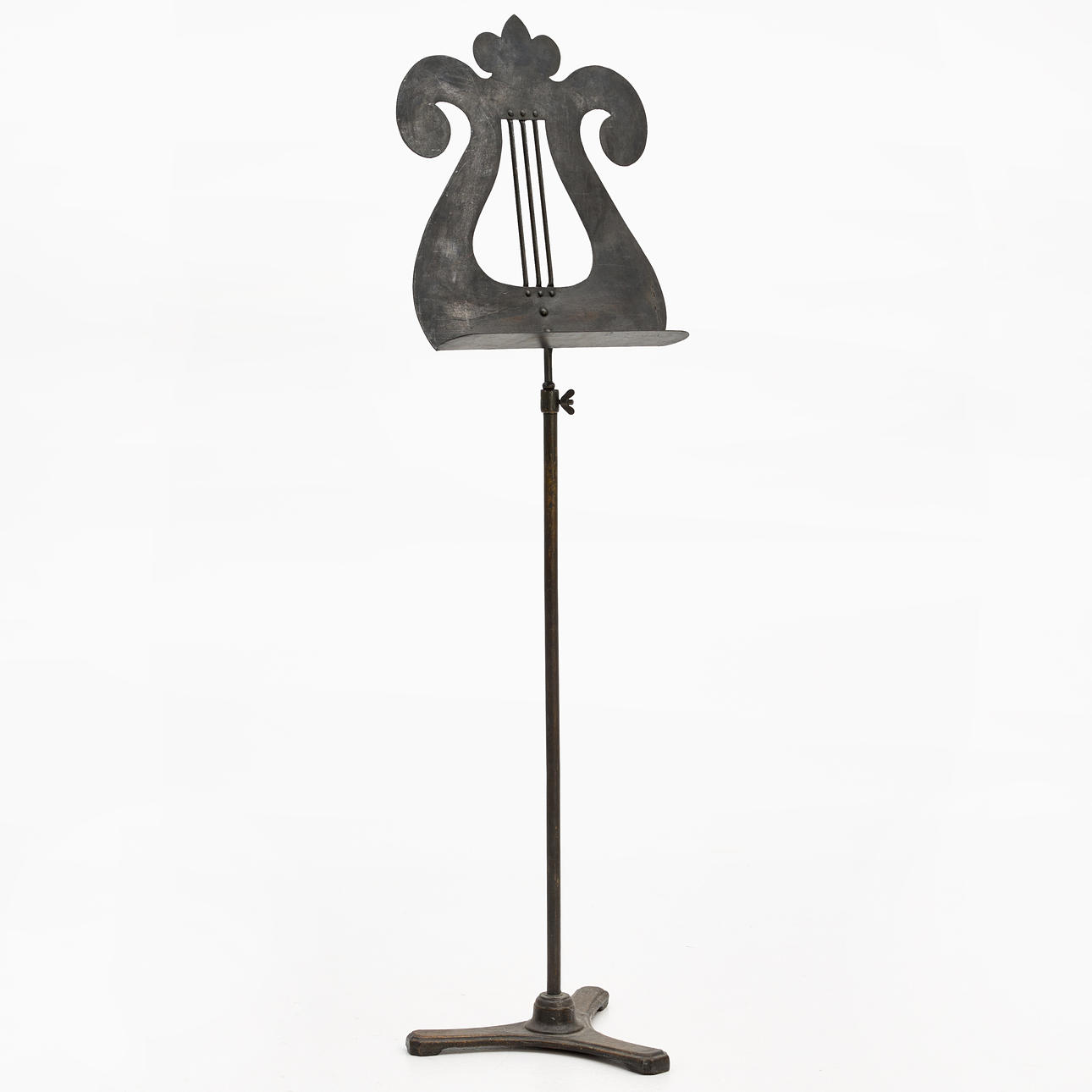 A metal music stand, 20th century, in the shape of a lyre, on a three-piece foot.