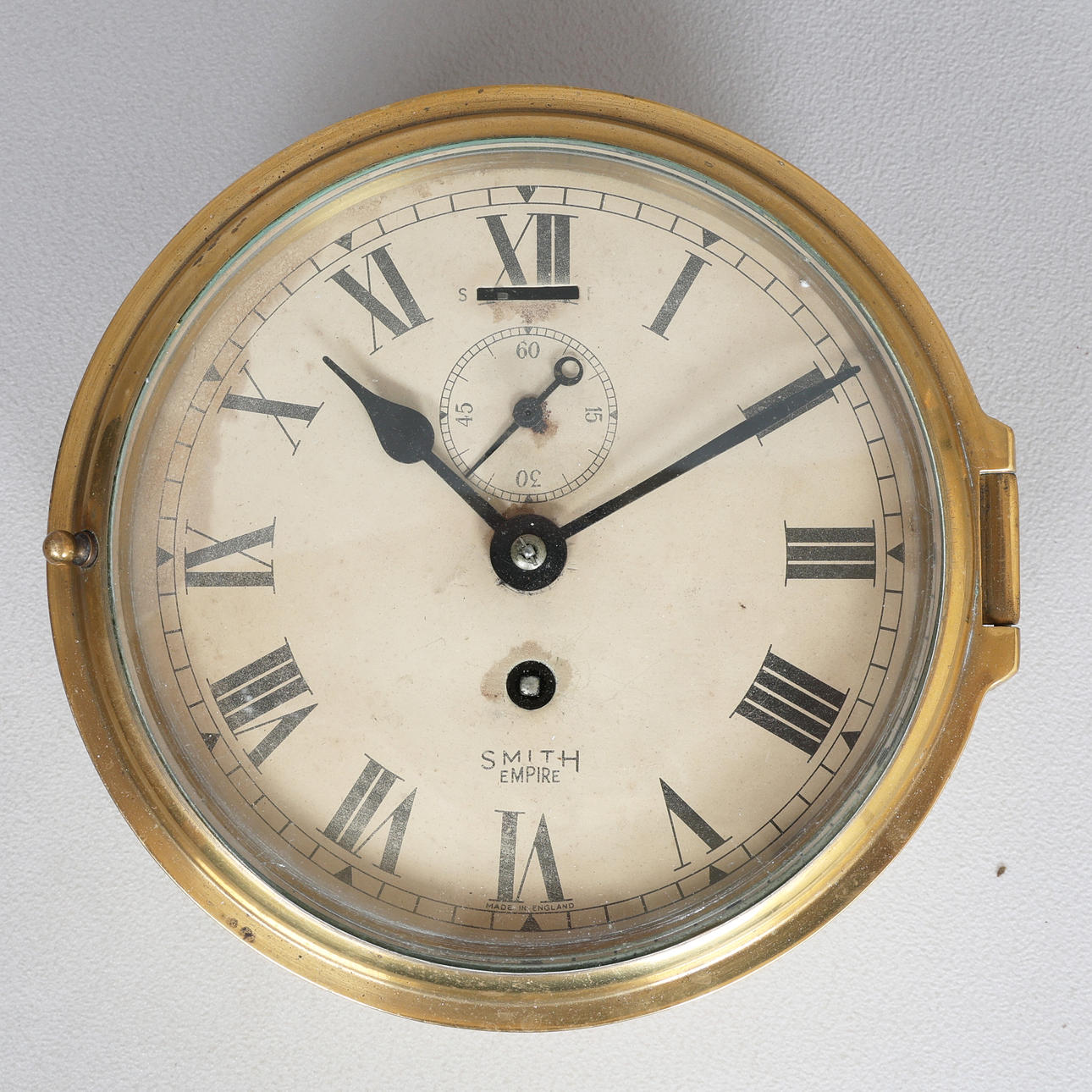 A SMITH EMPIRE BRASS SHIPS BULKHEAD CLOCK.