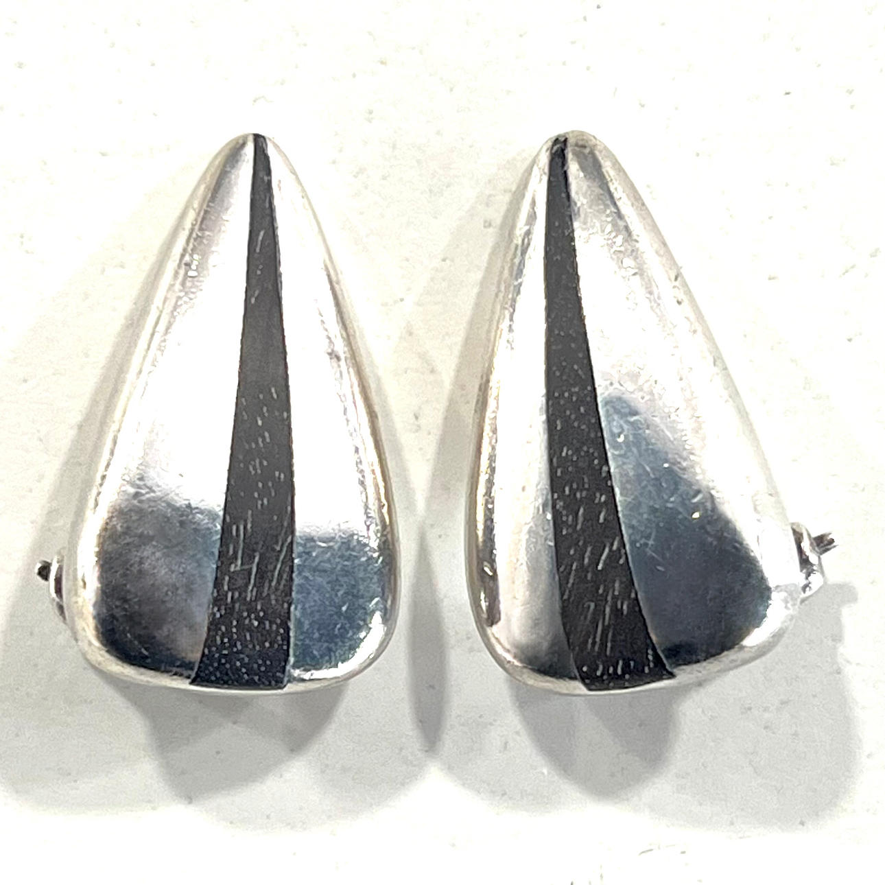 PUIG DORIA. Triangulära silverörhängen med centralt ebenholtsband.