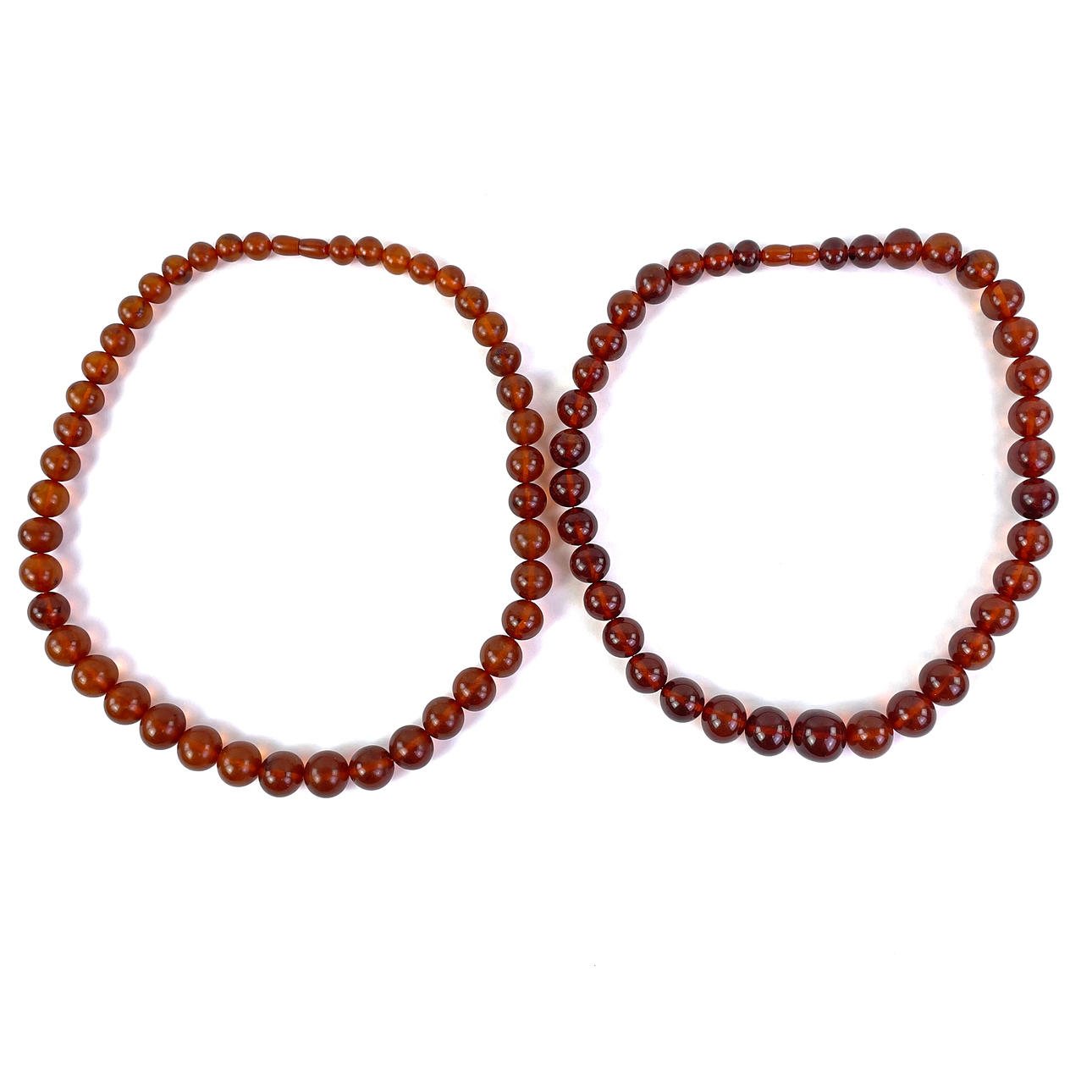 Et sæt med 2 halskæder, rav.