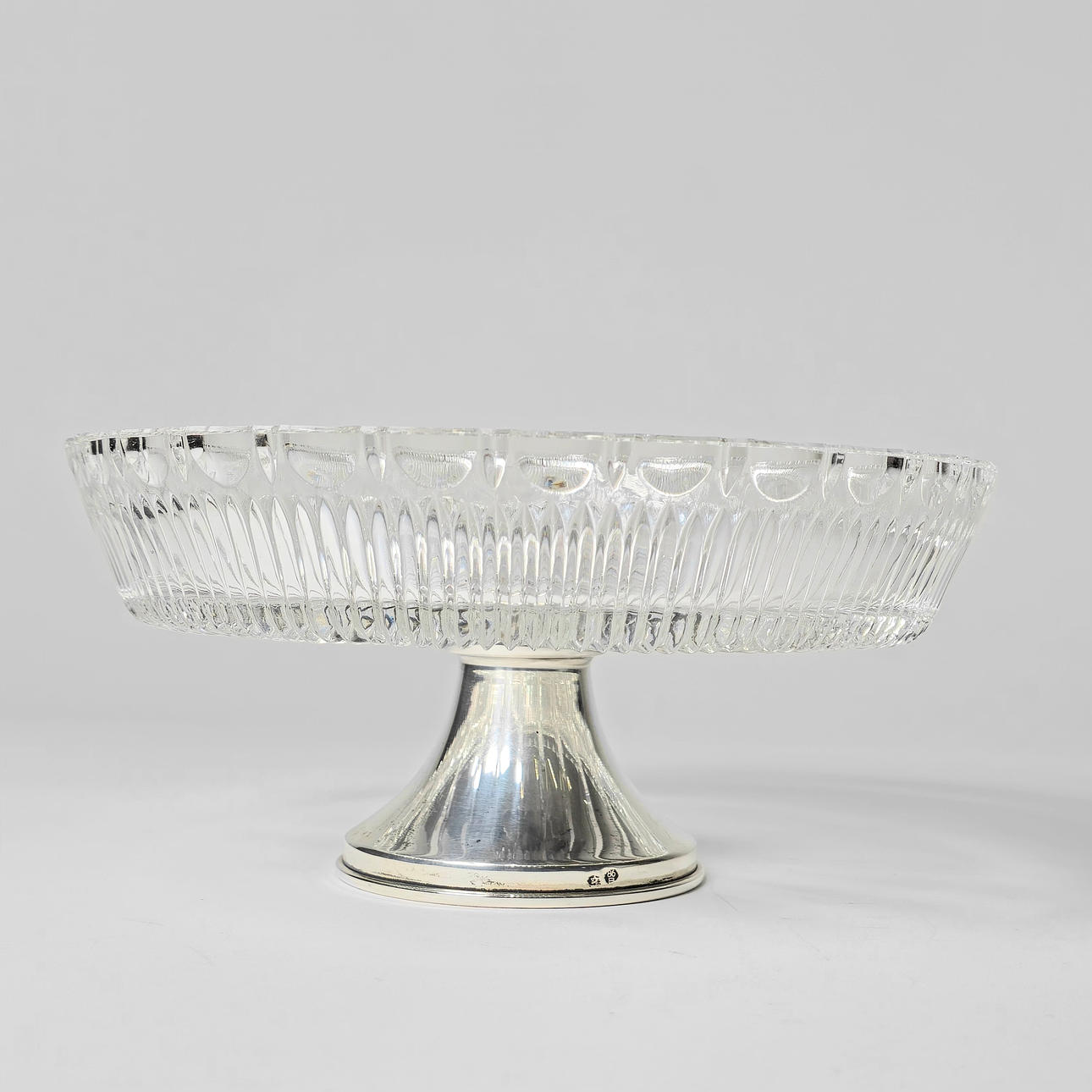 HERZSTÜCK AUS GESCHNITZTEM GLAS MIT SILBERNER BASIS.