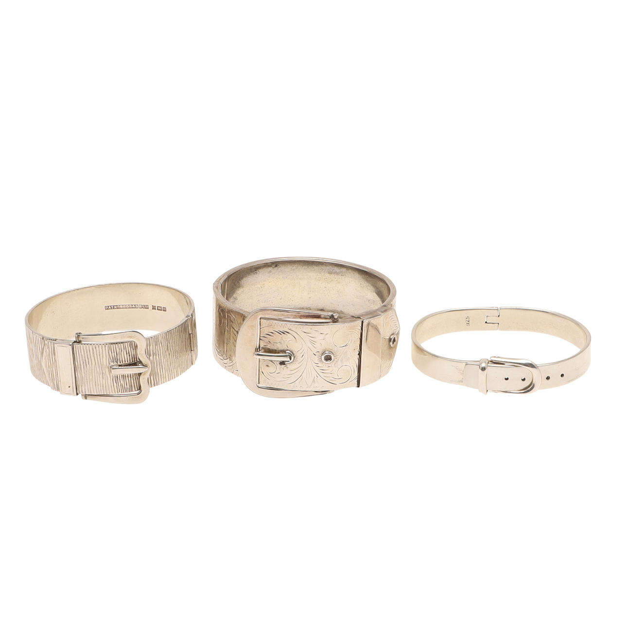 THREE SILVER BUCKLE BANGLES.