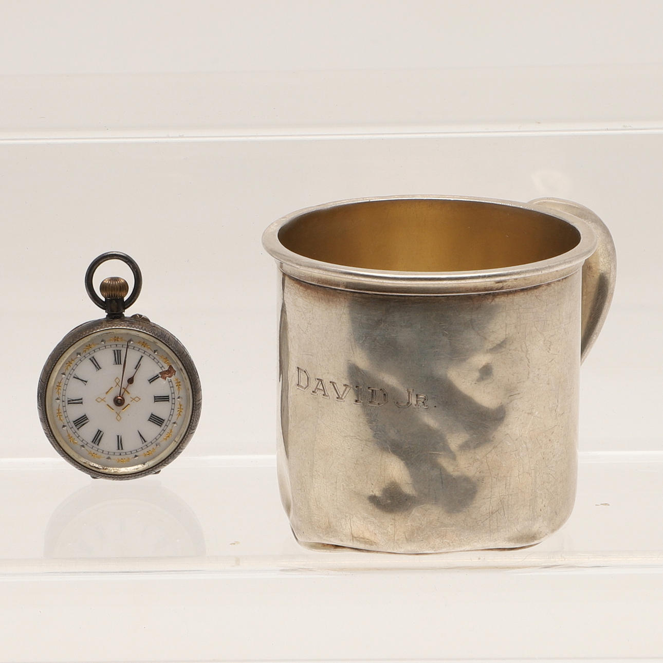 DOPMUGG I AMERIKANSKT SILVER OCH ETT SILVERFICKUR.