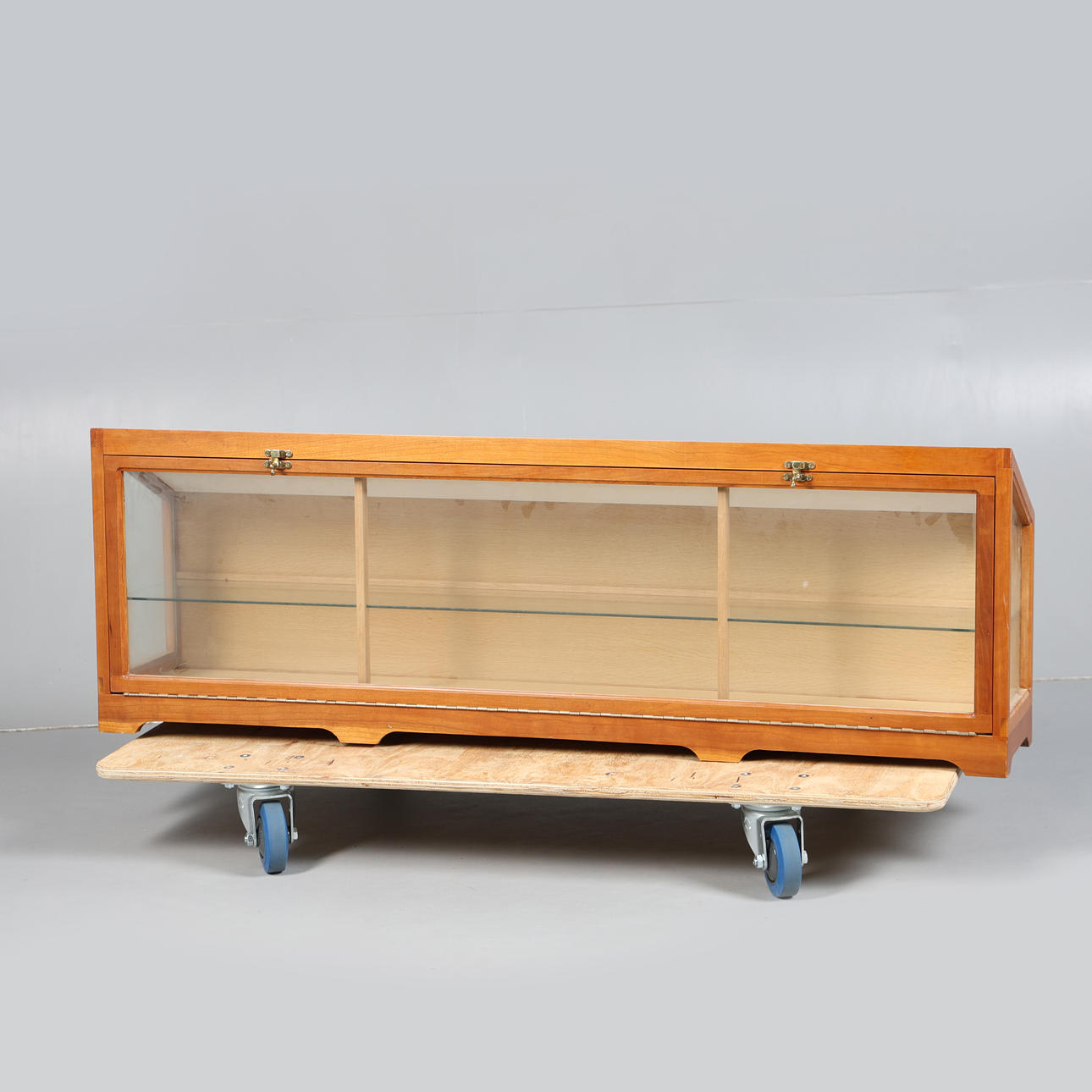 A LONG WOODEN GLAZED DISPLAY CABINET.