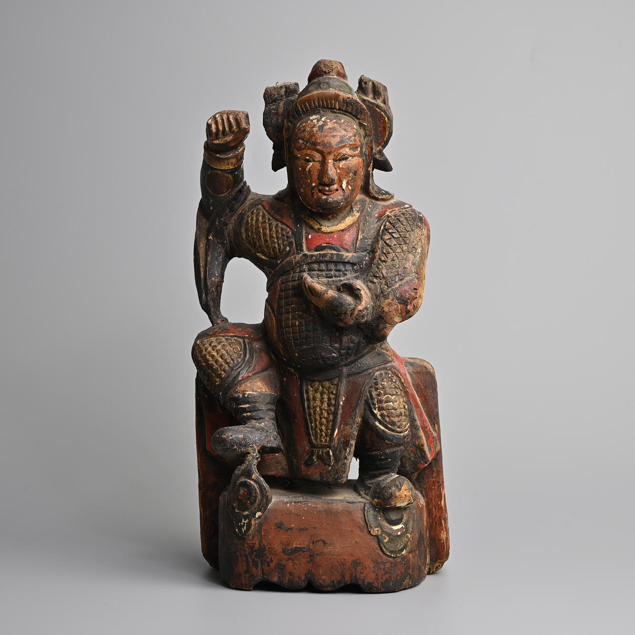 EINE CHINESISCHE, AUS HOLZ GESCHNITZTE UND POLYCHROM BEMALTE FIGUR EINES KRIEGERS AUS DER MING-DYNASTIE (1368-1644).