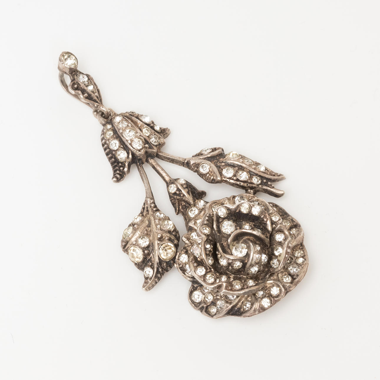 Eine silberne Brosche mit weißen Steinen.