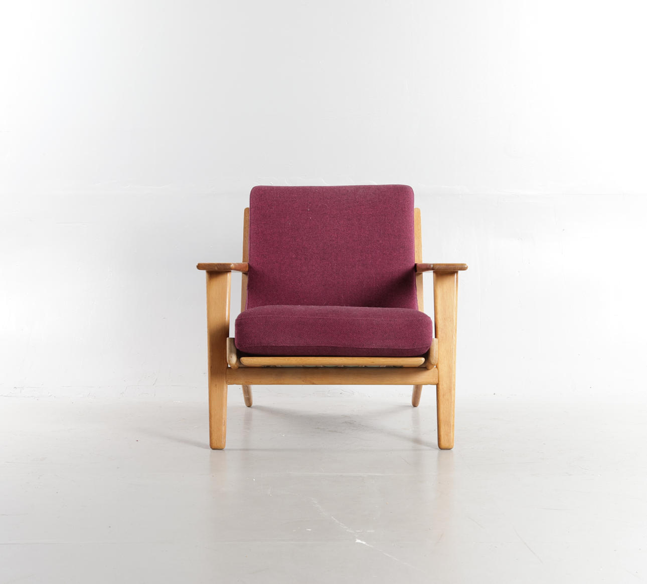 HANS J WEGNER. Low back armchair with oak frame, loose cushions in seat and back upholstered wool. Designed in 1953. Made and marked at Getama, 'GE 290'.