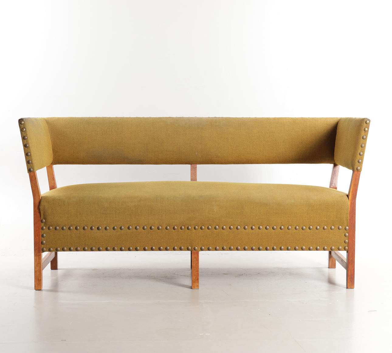 DANSK SNEDKERMESTER. Freestanding oak sofa, hovering back and seat upholstered in wool, brass-stitched, mid 20th century.