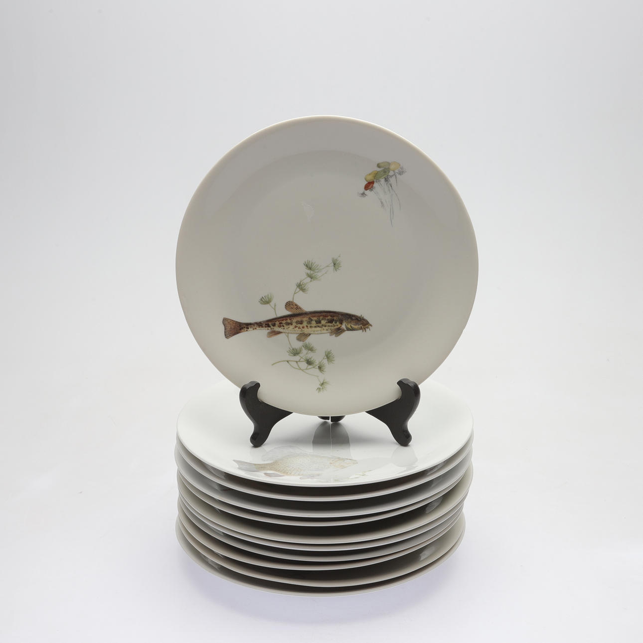 11 ceramic fish plates, marked F.