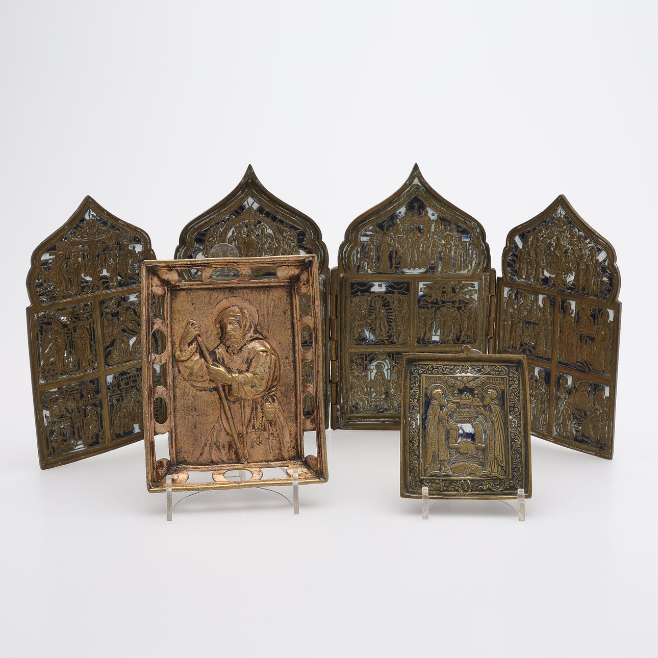 RUSSIAN TRAVEL ICONOSTASIS IN BRASS AND ENAMEL, “EN”, WITH THE TWELVE GREAT FEASTS AND THE VENERATION OF THE ICONS WITH THE THEOTOKOS. 19TH CENTURY. AS WELL AS TWO OTHERS.