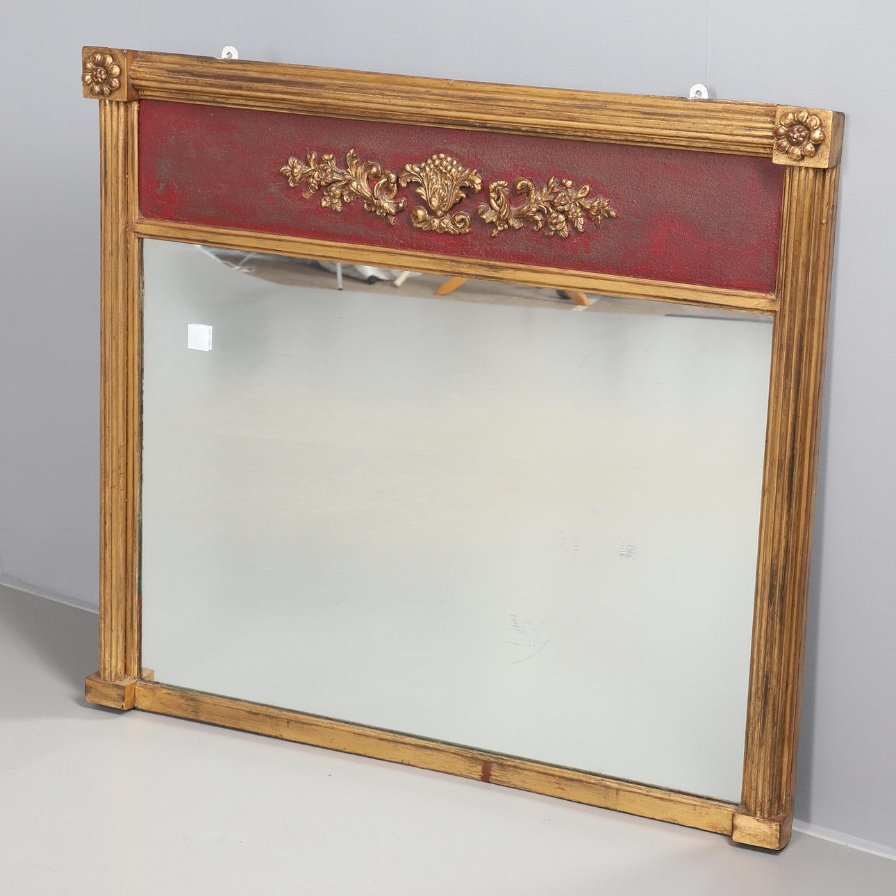 A GILT FRAMED OVERMANTLE MIRROR.