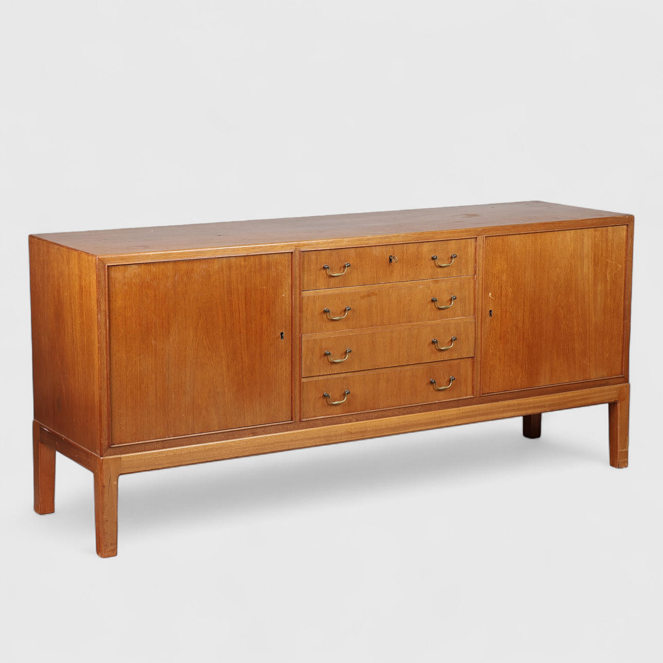 DANSK SNEDKERMESTER. Sideboard of mahogany with profiled legs, front with two doors and four drawers, brass handles, Denmark, 1940/50s.