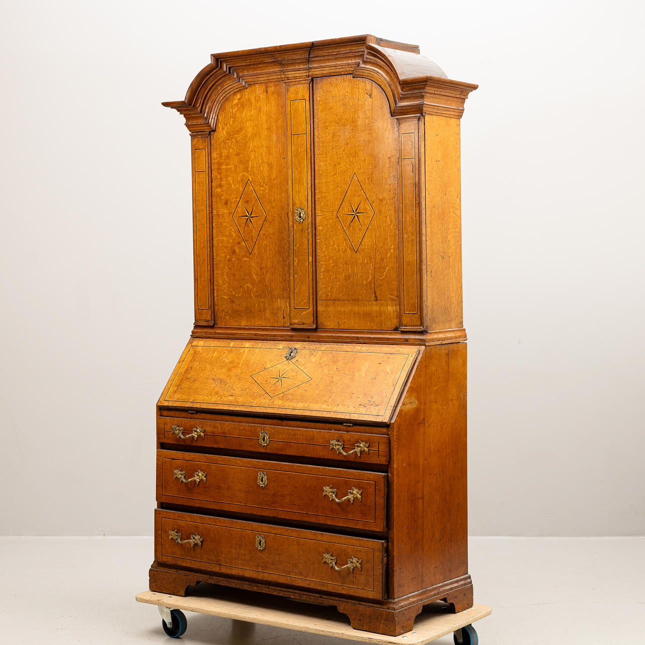 An 18th century intarsia root-veneer dining cabinet with sloping flap.