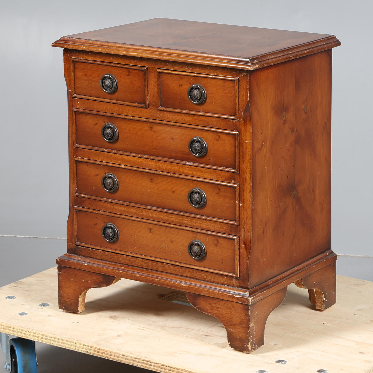 UNA CÓMODA MESITA DE NOCHE CHAPADA EN MADERA DE TEJO.