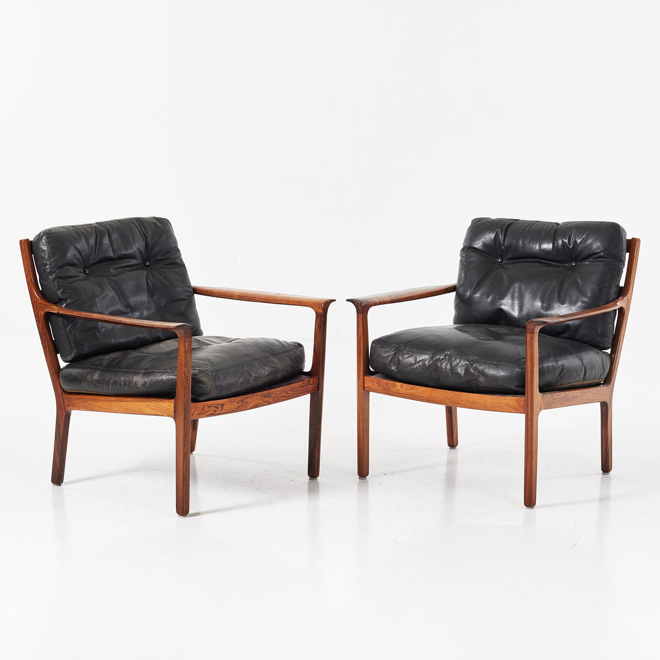 A pair of armchairs, probably Brothers Andersson, frame in Riopalisander, black leather upholstery, 1960s.