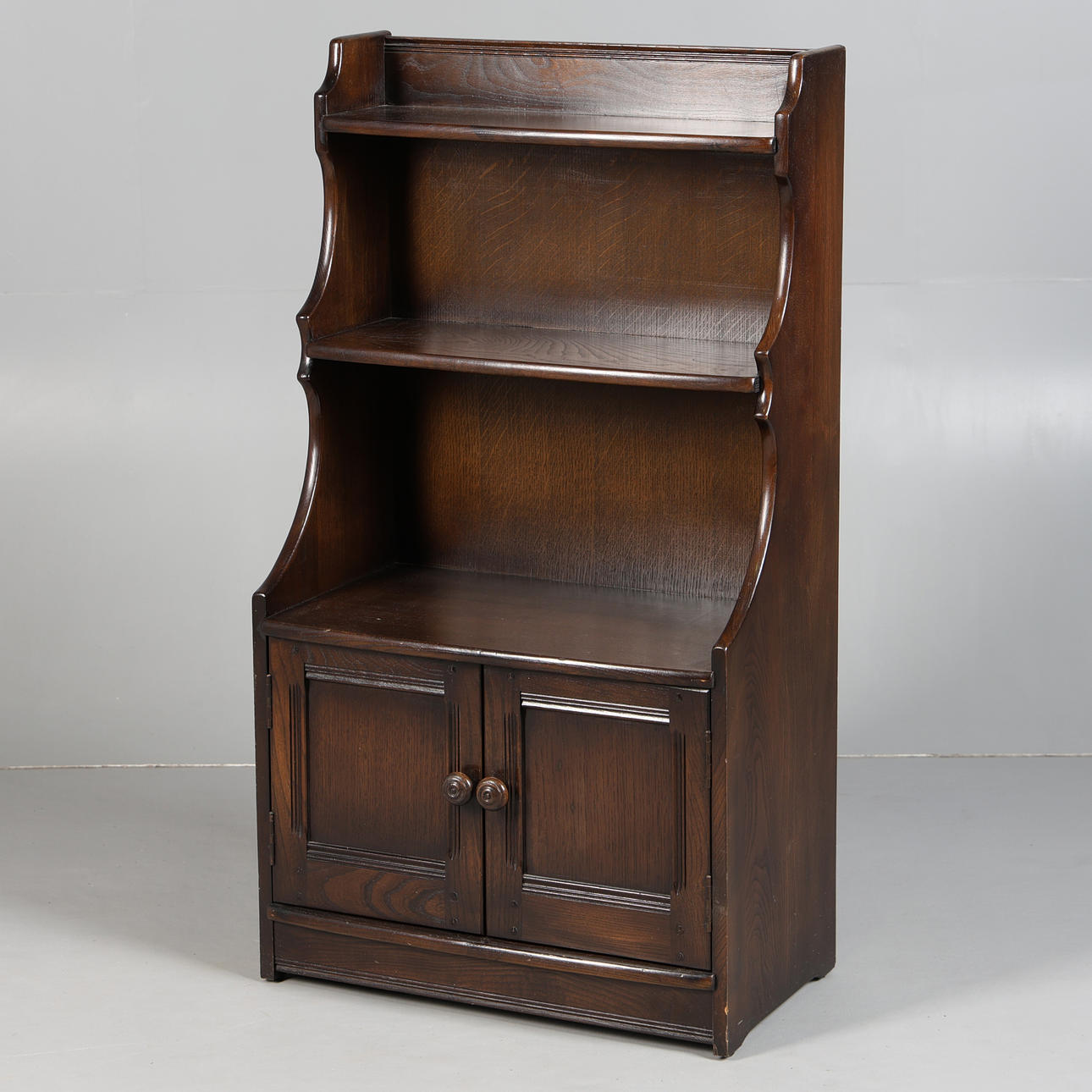 AN ERCOL WATERFALL BOOKCASE.