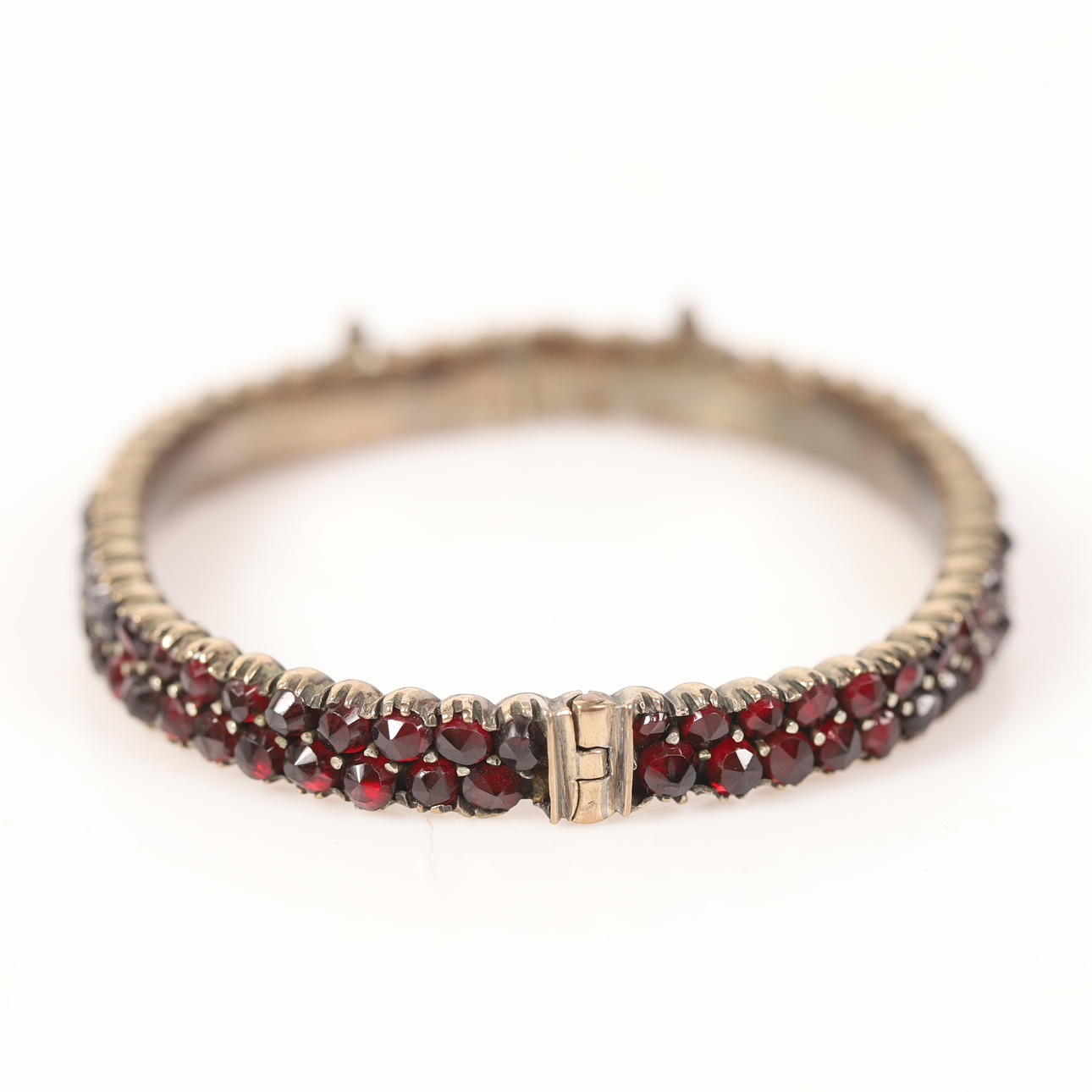 BRACELET, white metal with garnets.