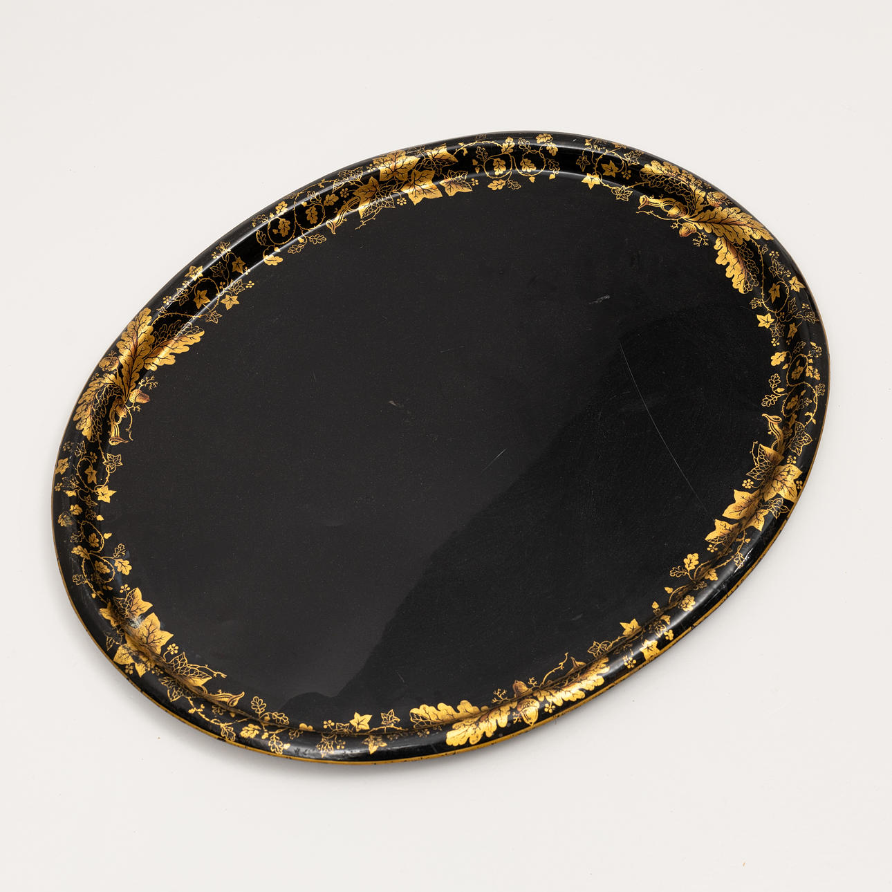 TRAY, sheet metal, gold leaf loop against blackened base.