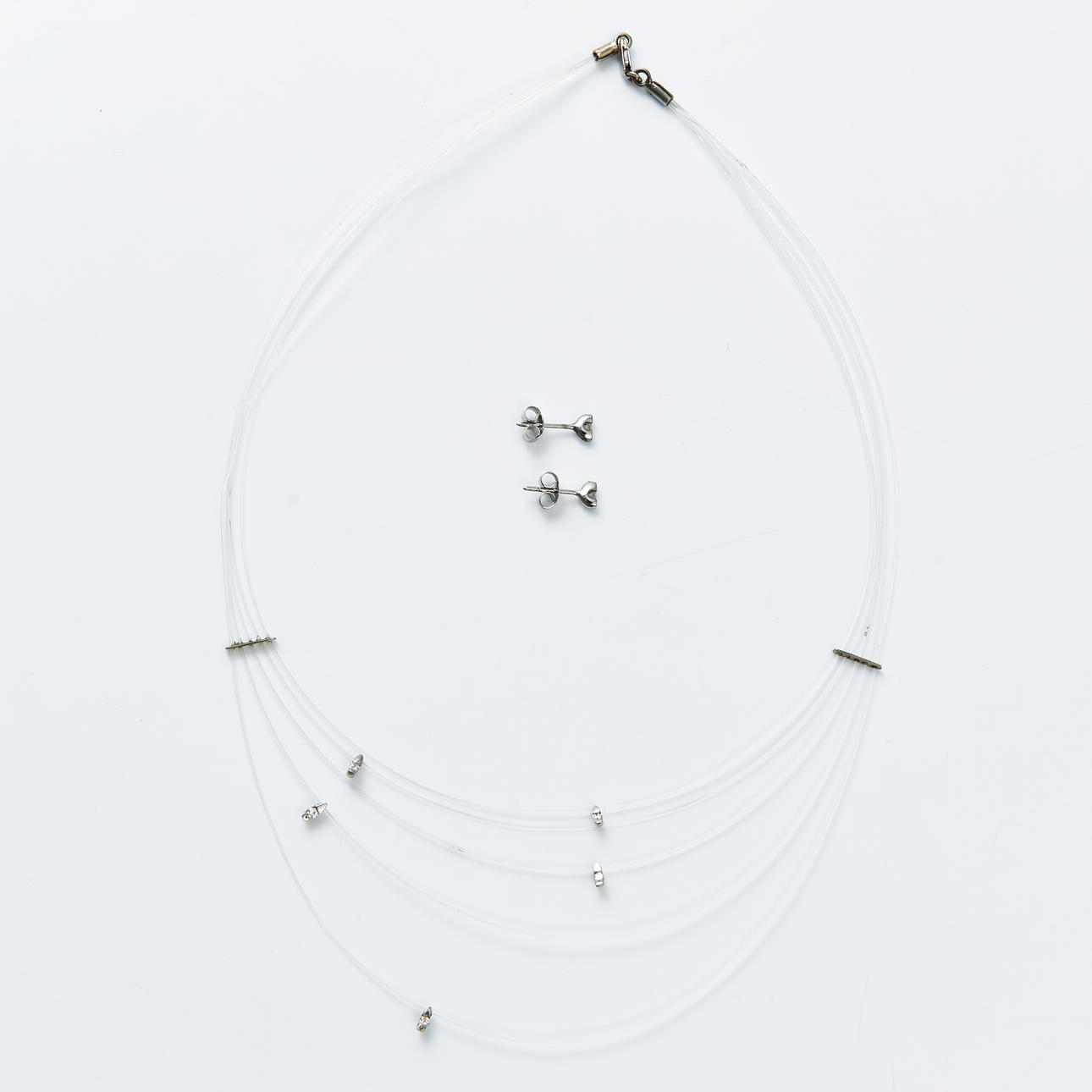 NECKLACE, nylon thread, 5 removable decor elements at the front with brilliant cut diamonds total approx 0,20 ct, clasps and fasteners 18 k rhodium plated white gold, matching EARRINGS, 1 pair, 2 brilliant cut diamonds total approx 0,06 ct.