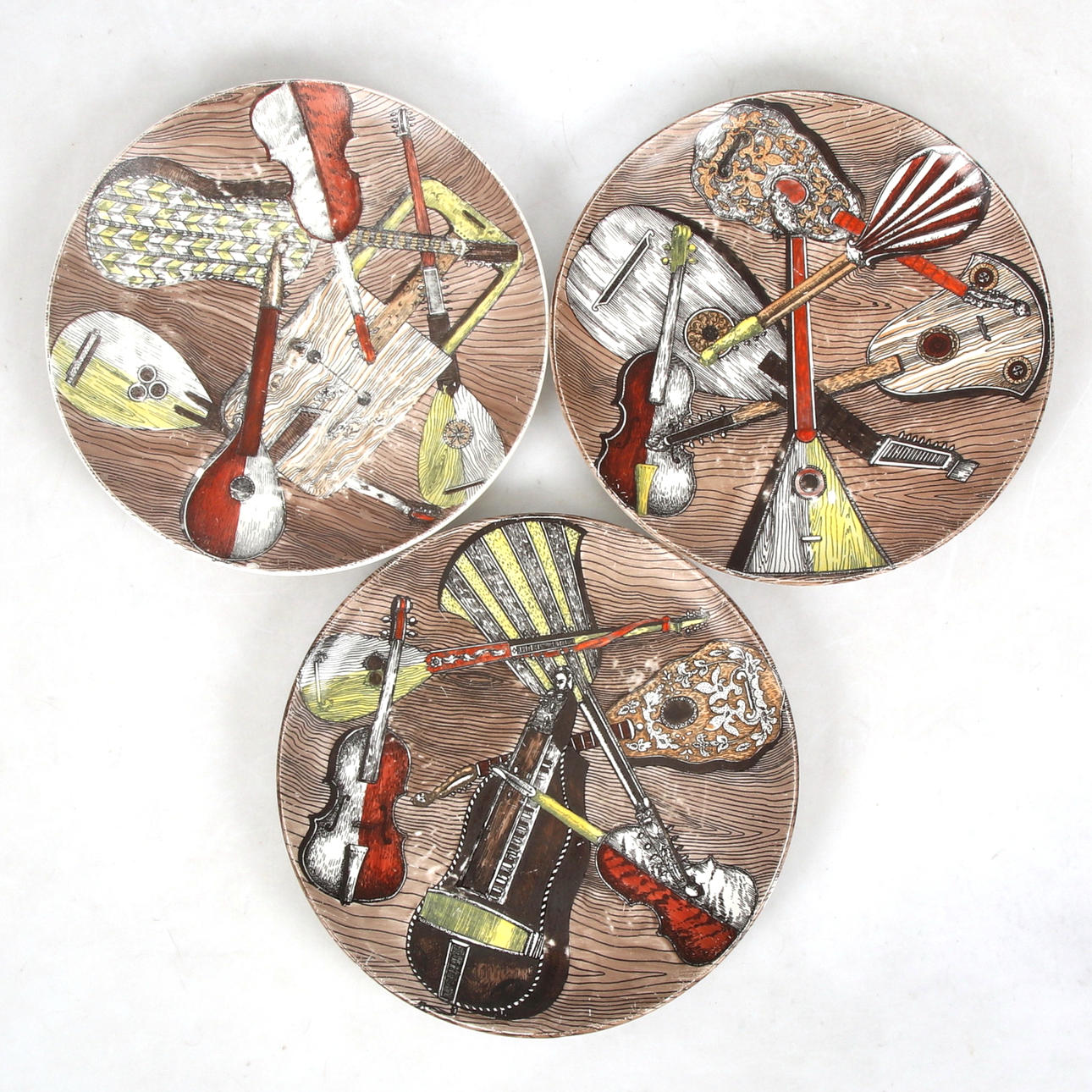 PIERO FORNASETTI, a set of three porcelain plates, “Strumenti 