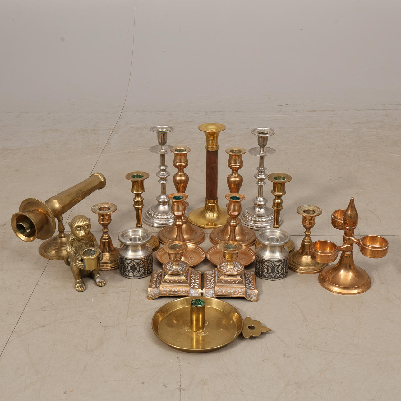A set of 19 candlesticks, brass/tin/ore.