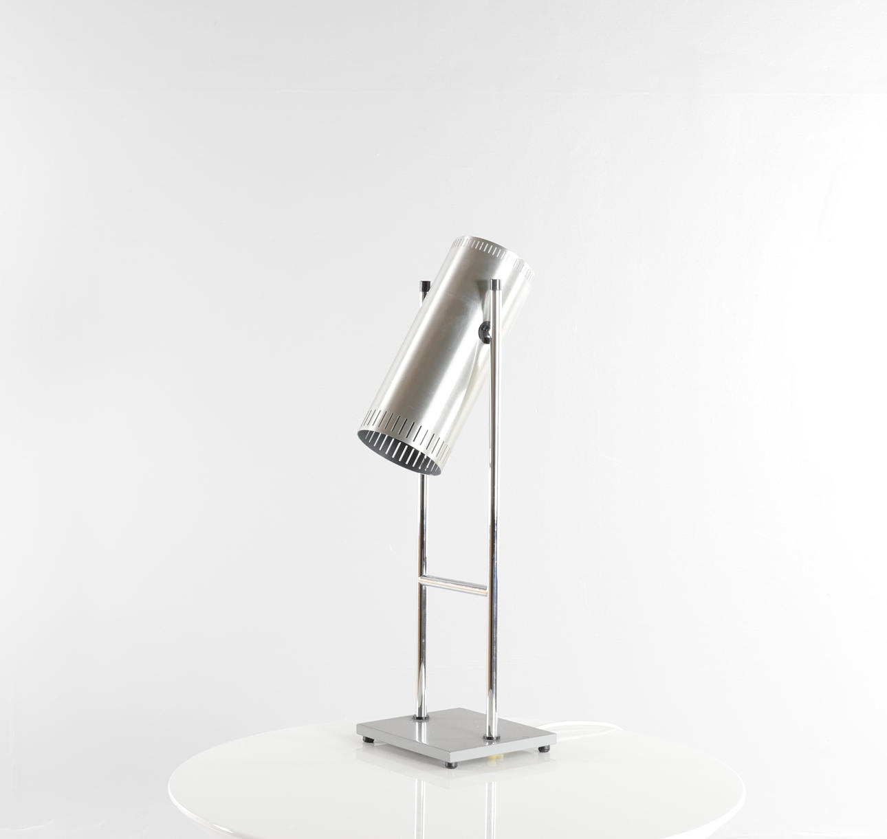 JO HAMMERBORG. “Trombone”, chrome-plated and brushed metal table lamp with adjustable screen. Set up on square, gray lacquered base. Top part of screen with power button. Made and marked at Fog & Mørup.