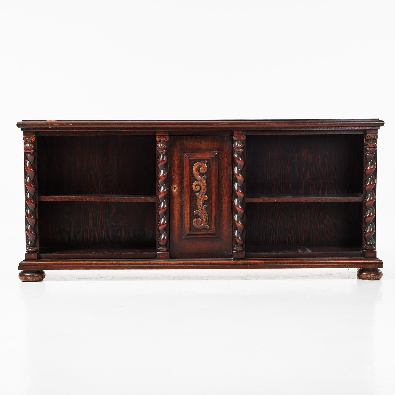 A 20th century bookcase, stained oak veneer, partly cut decoration in the form of columns.