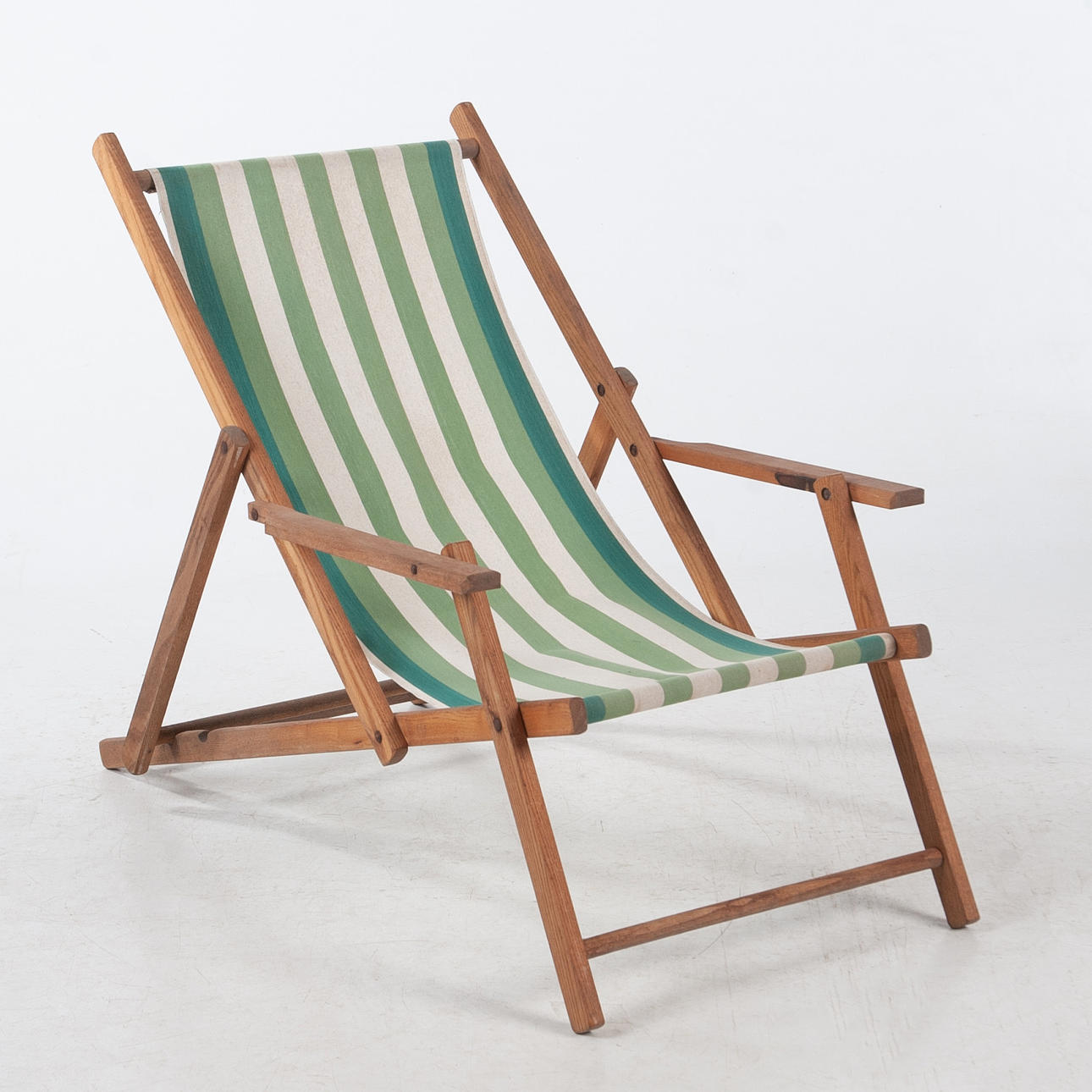 SOLSTOL I TRÄ MED RANDIGT TYG OCH ARMSTÖD.