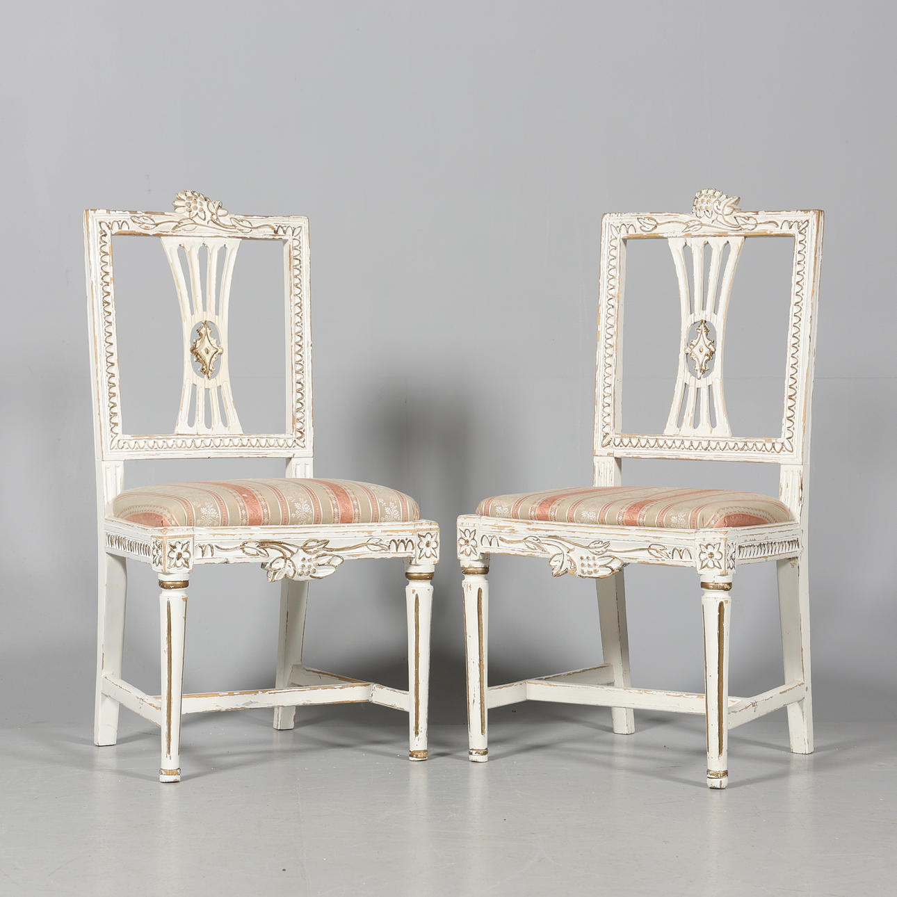 A pair of Gustavian style chairs.