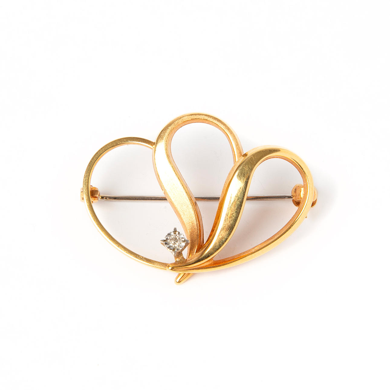 A 18K gold brooch with octagonal cut diamond.