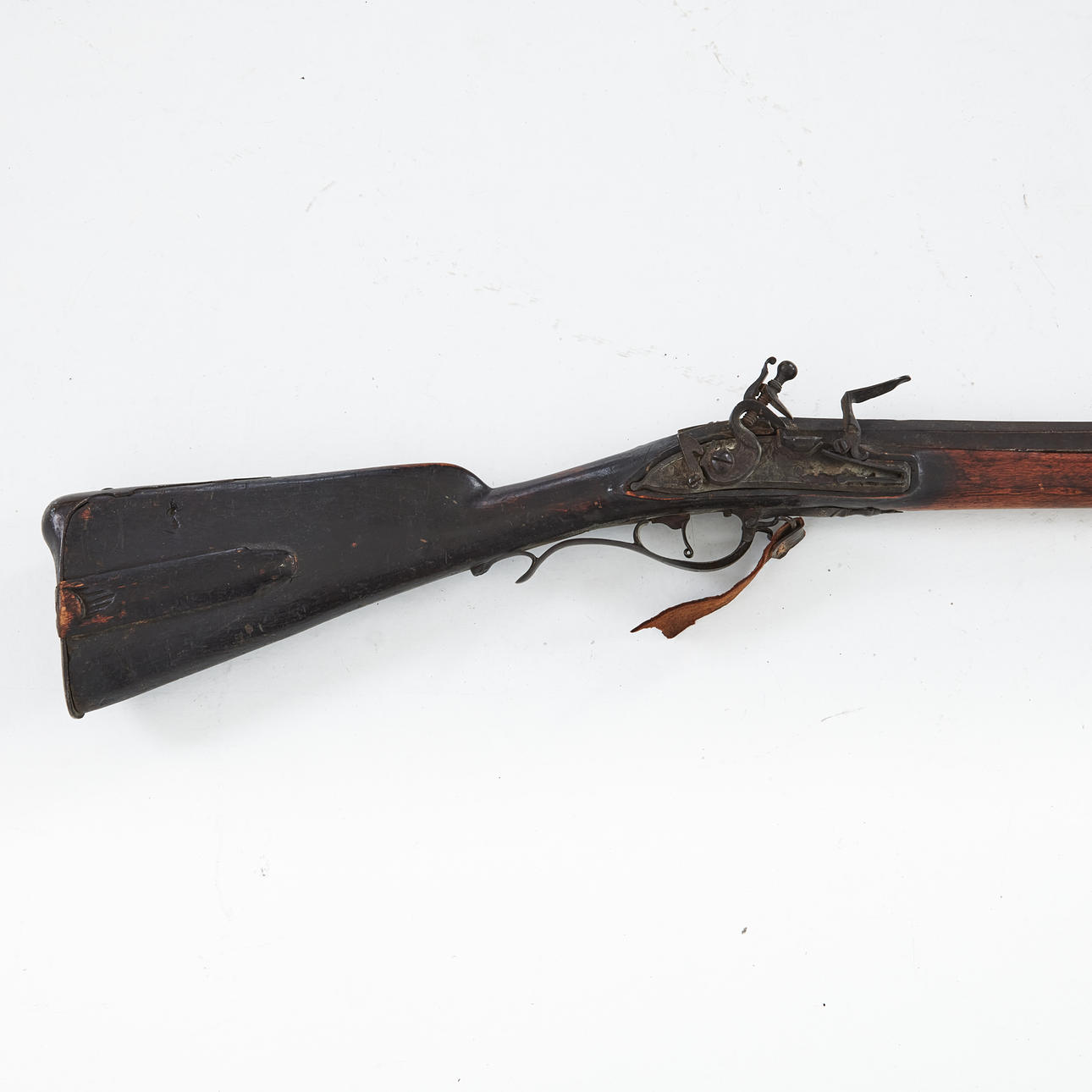 A 18th-century flintlock bouncer, pipe with octagonal chamber piece, lock plate with engraved decoration of trophies, blackened log.