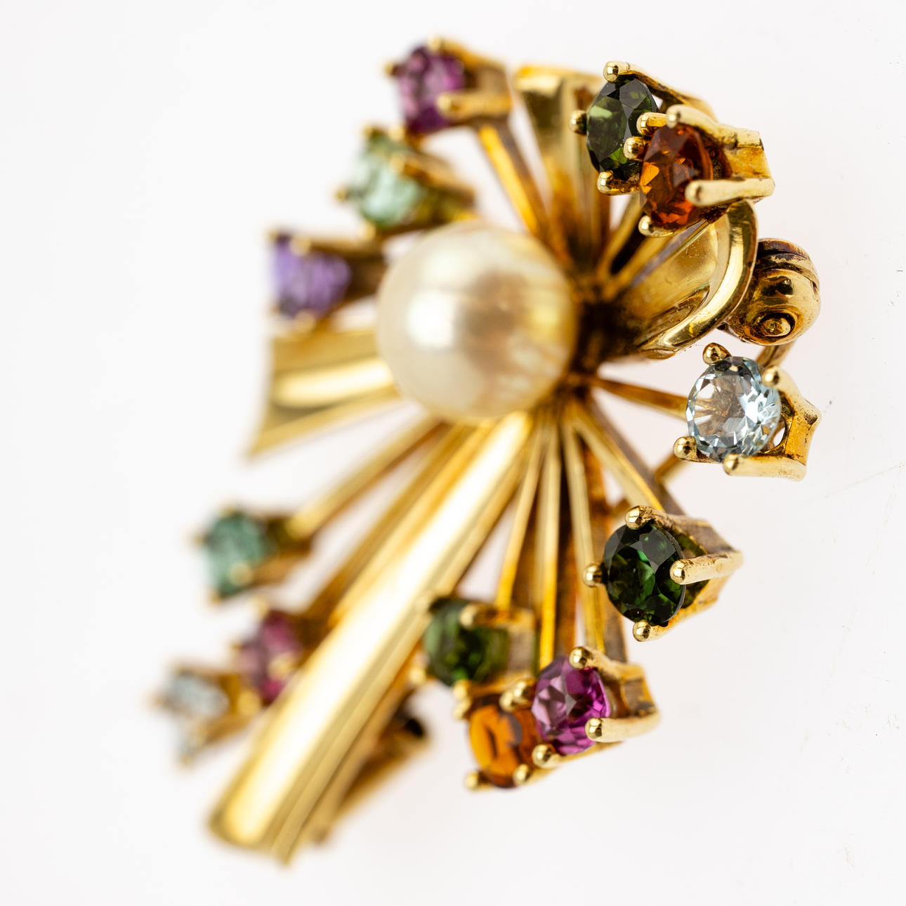 Broche con gemas multicolores y una perla.