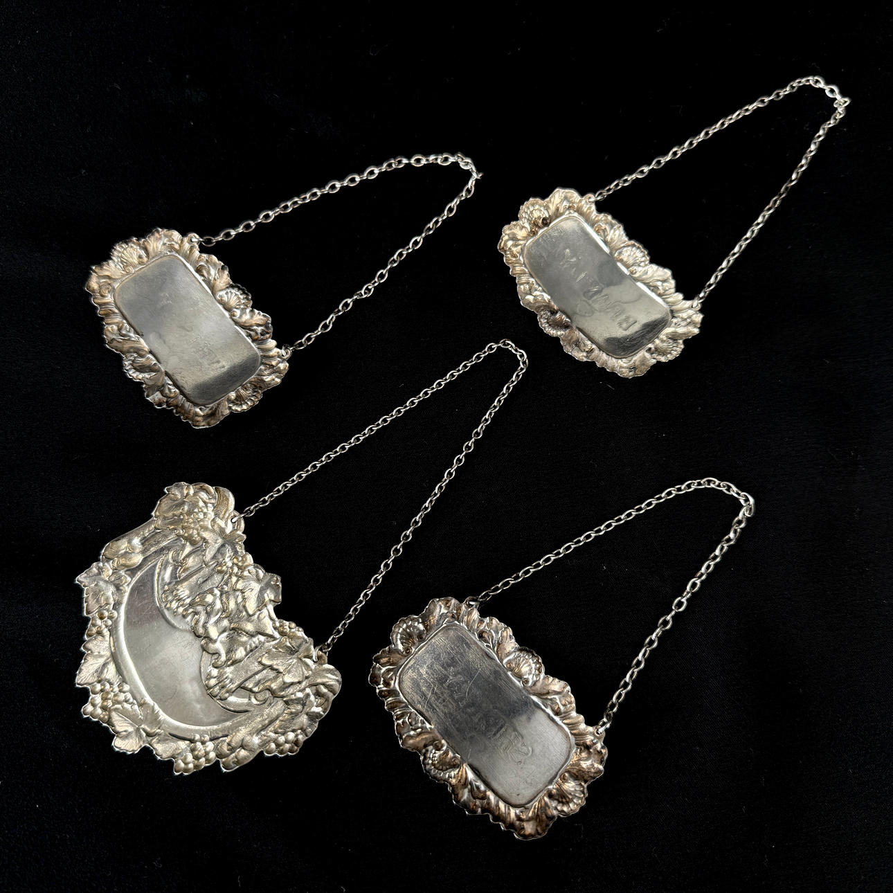 FOUR SILVER DECANTER LABELS.